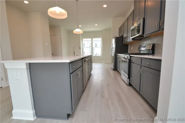 a kitchen with stainless steel appliances a refrigerator stove and microwave