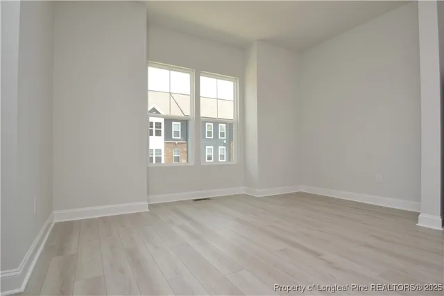 a view of kitchen with stainless steel appliances wooden floor and large window
