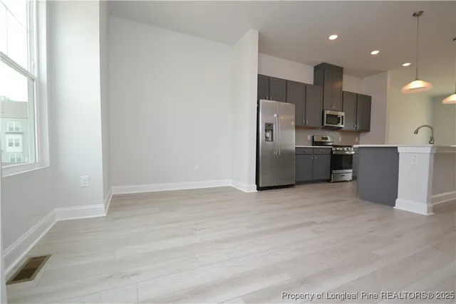 a view of a big room with wooden floor and windows