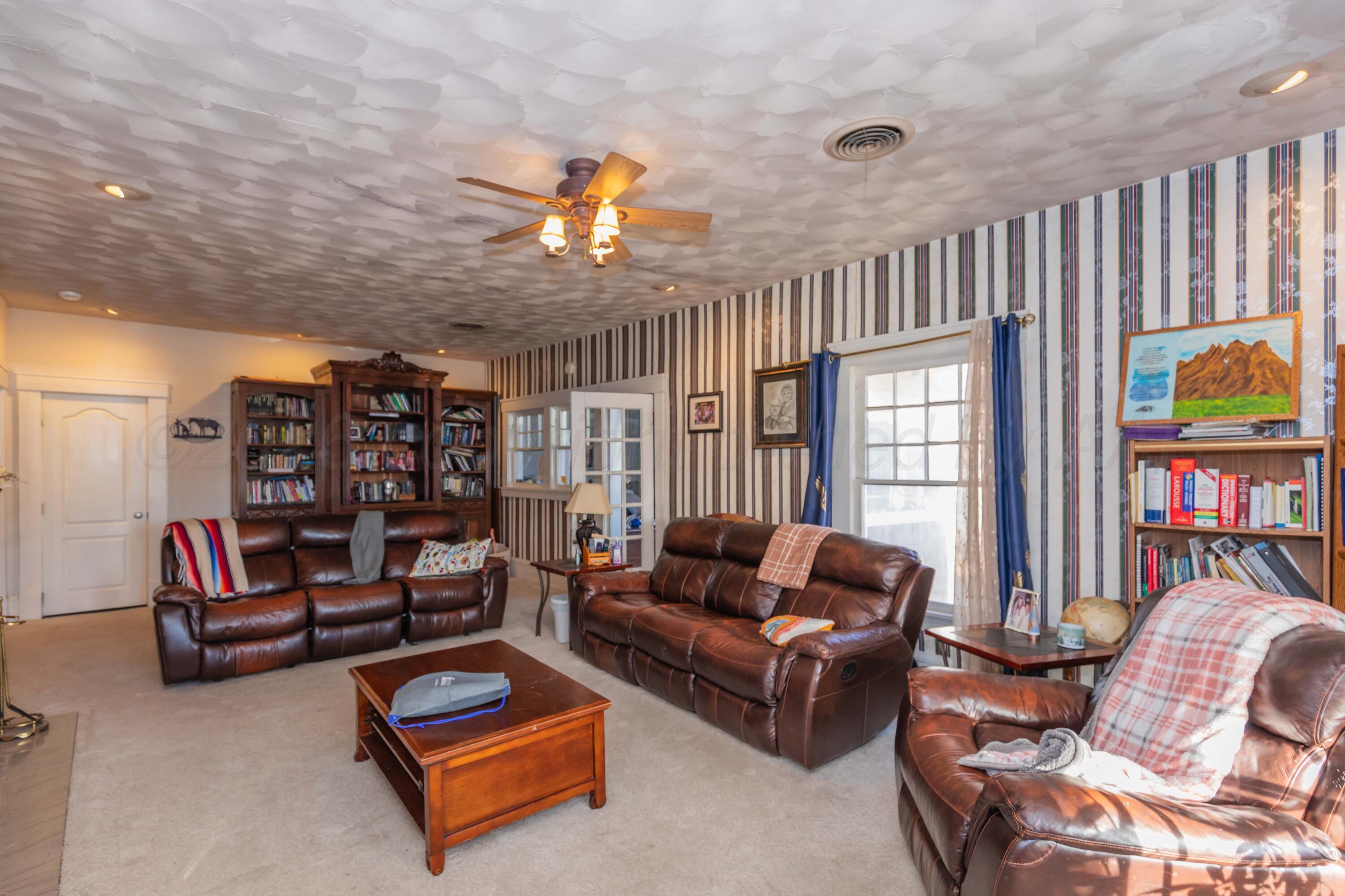 1502 South Monroe Street Amarillo, TX 79101 - Photo 18 of 35 a living room with furniture a rug and a bookshelf