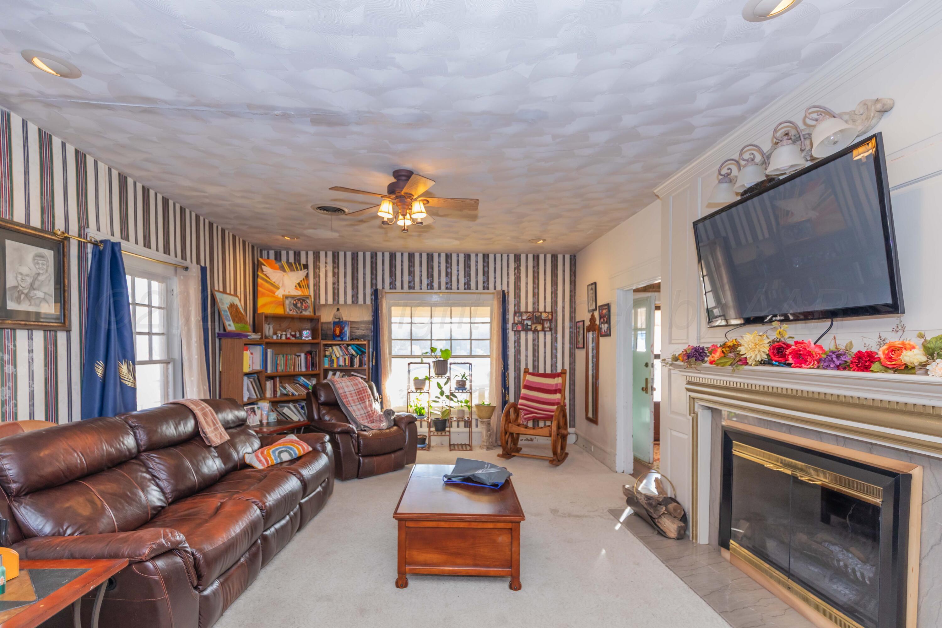 1502 South Monroe Street Amarillo, TX 79101 - Photo 3 of 35 a living room with furniture a flat screen tv and a fireplace