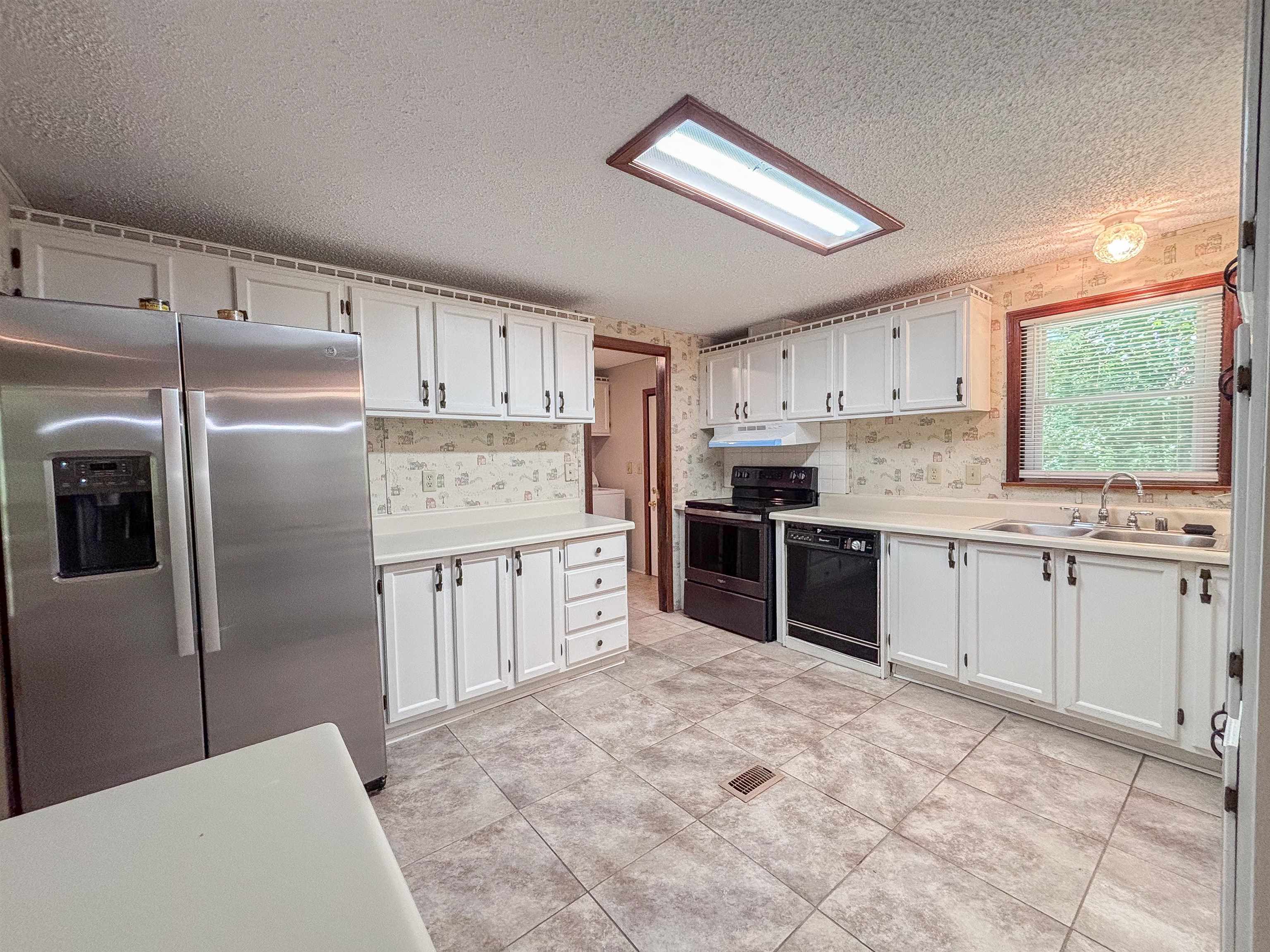 471 Milton Road Millington, TN 38053 - Photo 5 of 30 Kitchen featuring a stainless steel refrigerator, white cabinetry, a black range, a black dishwasher, and tiled flooring