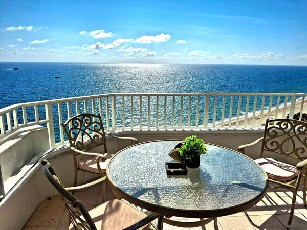 a view of a chairs and table in the balcony
