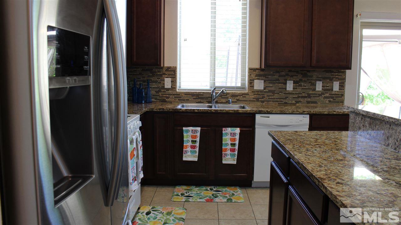 2700 Gulling Court Reno, NV 89503 - Photo 3 of 13 a kitchen with granite countertop a refrigerator a stove and a sink