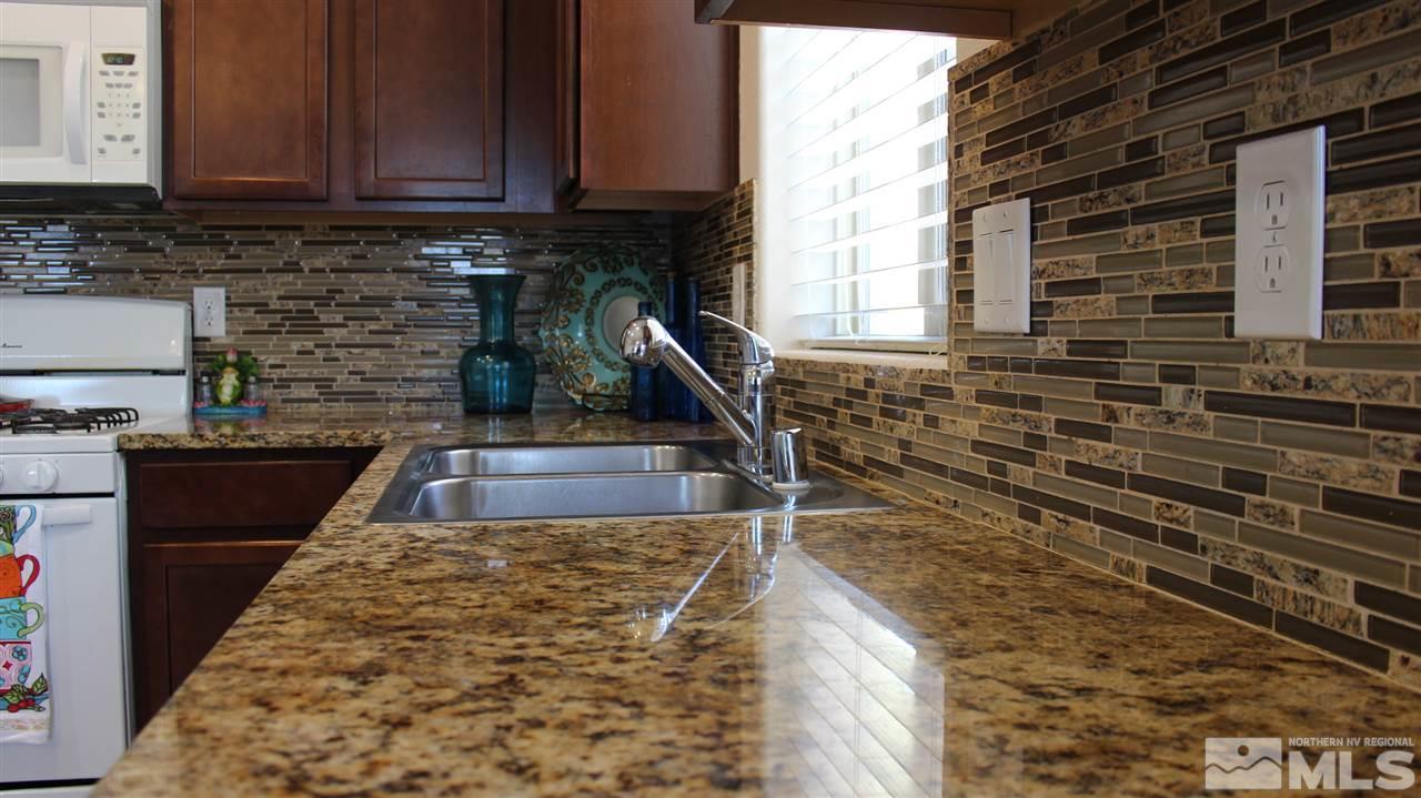 2700 Gulling Court Reno, NV 89503 - Photo 4 of 13 a kitchen with granite countertop a stove a sink and a microwave