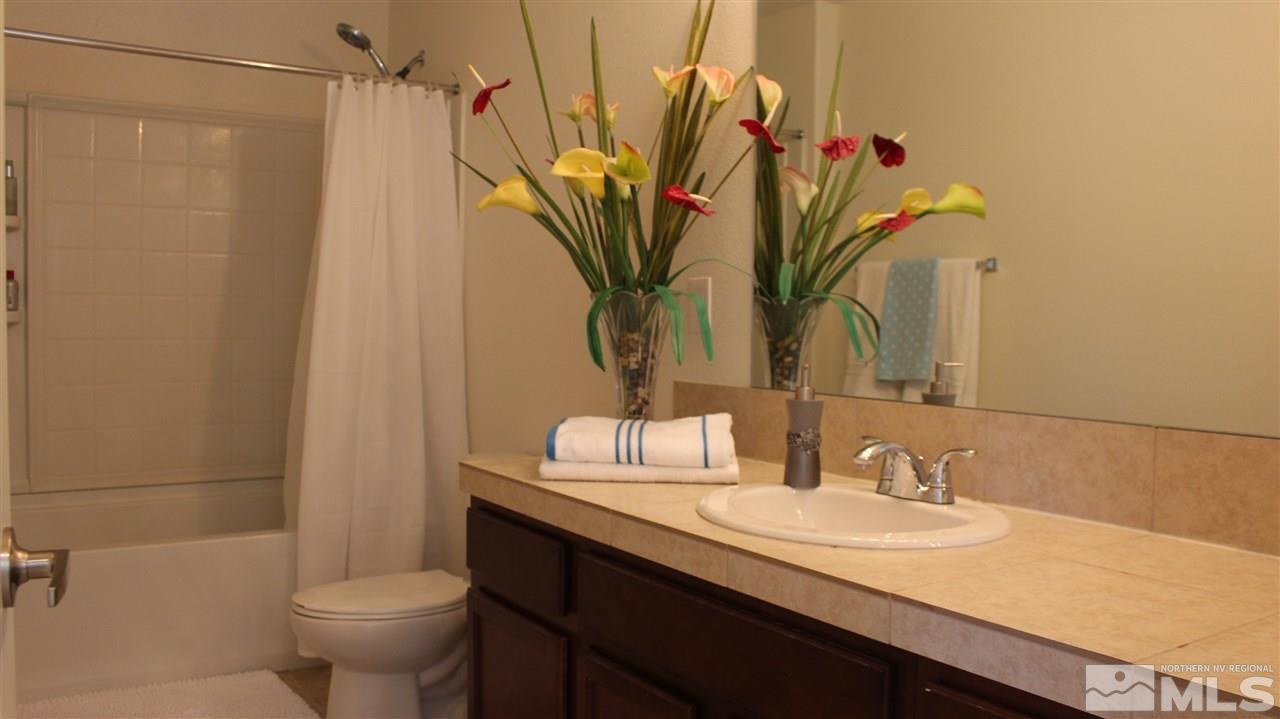 2700 Gulling Court Reno, NV 89503 - Photo 8 of 13 a bathroom with a granite countertop sink a toilet and a mirror