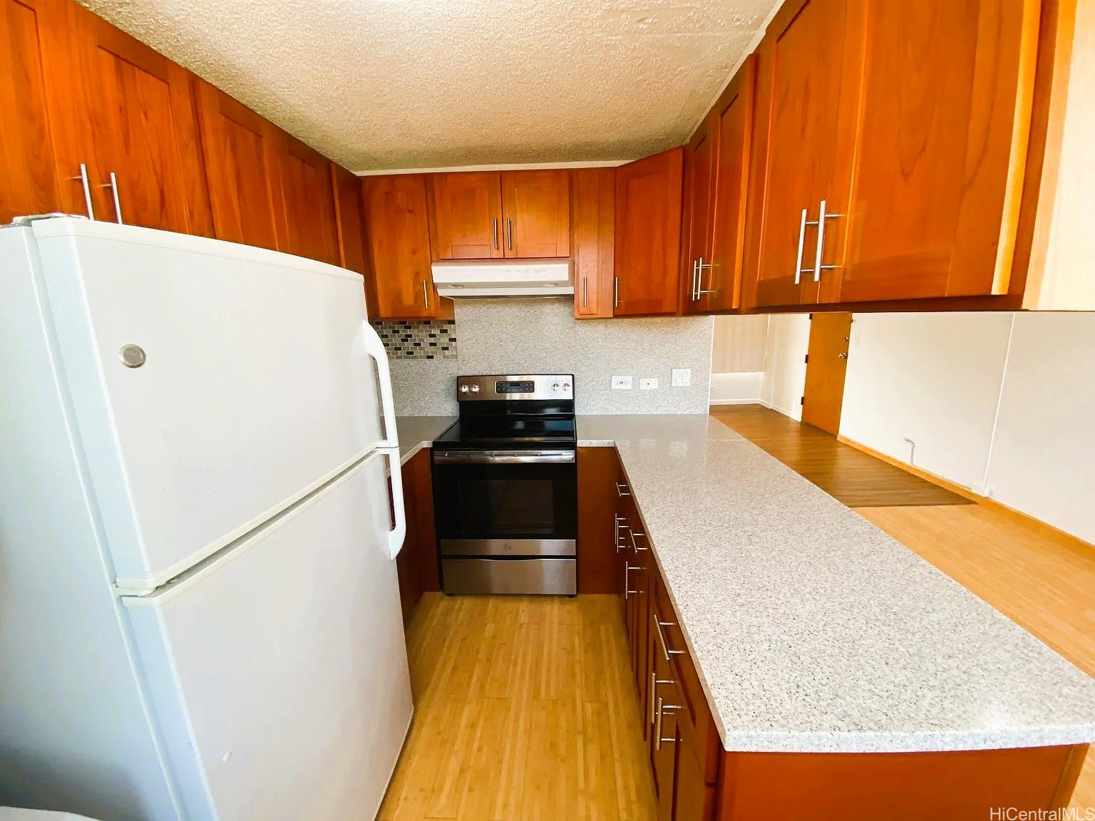 3033 Ala Ilima Street, Unit 1001 Honolulu, HI 96818 - Photo 3 of 12 a kitchen with a refrigerator a stove top oven a sink and cabinets