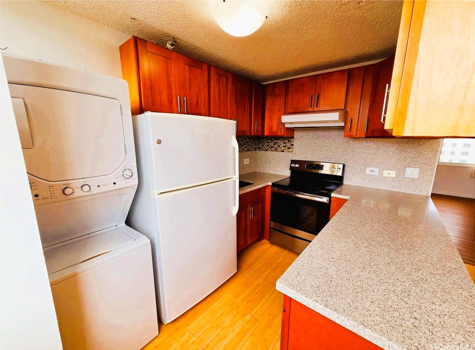 3033 Ala Ilima Street, Unit 1001 Honolulu, HI 96818 - Photo 4 of 12 a kitchen with a refrigerator a stove top oven and cabinets