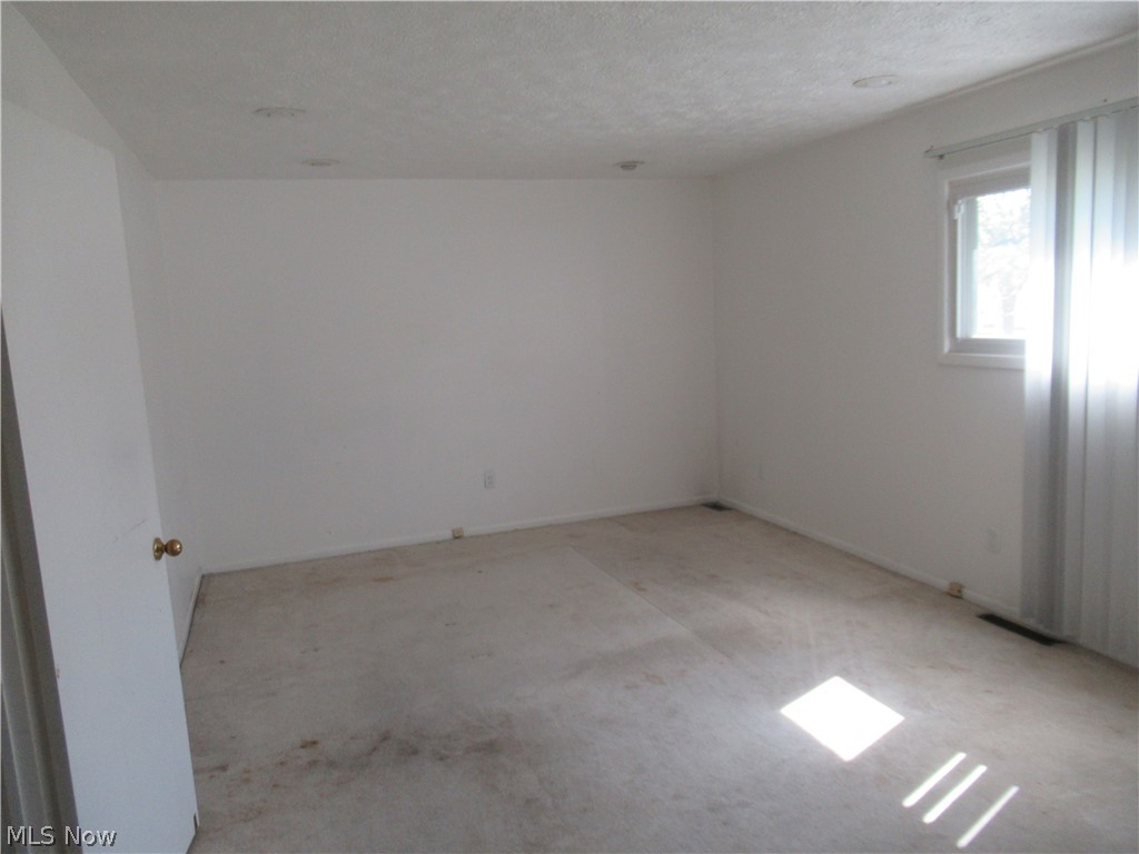 6033 Randy Road Bedford Heights, OH 44146 - Photo 11 of 19 Spacious room featuring white walls, recessed lighting, and a single window with vertical blinds