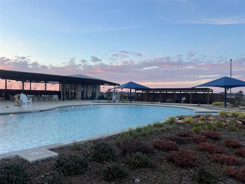 427 Ashbrook Way Princeton, TX 75407 - Photo 15 of 25 a view of a lake with a table and chairs under an umbrella