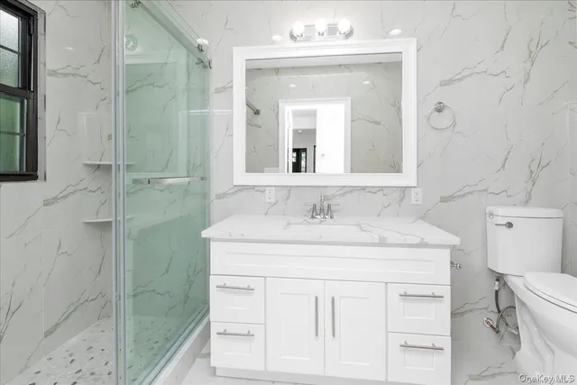 a bathroom with a sink toilet vanity and shower