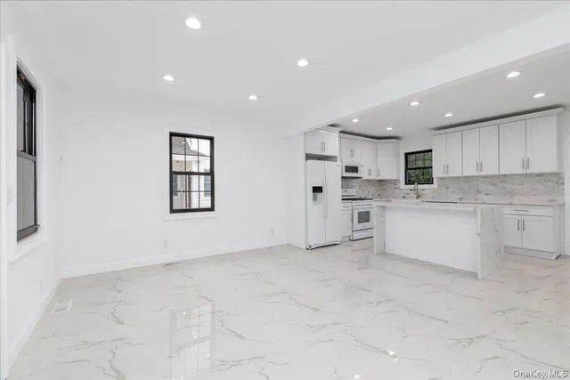 a view of kitchen with kitchen island and stainless steel appliances