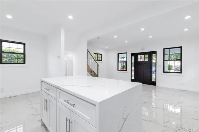 a large white kitchen with sink and refrigerator