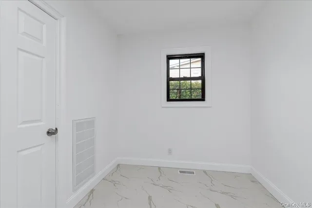 a view of a small space with wooden floor and a window