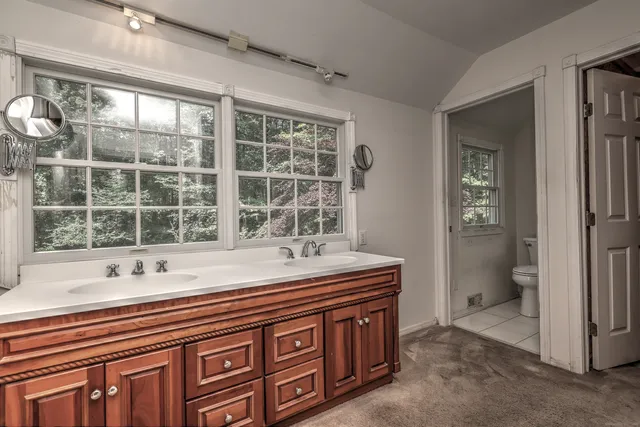 a spacious bathroom with double vanity and a large mirror