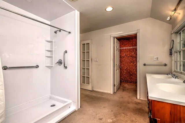 a bathroom with a tub sink shower and a mirror
