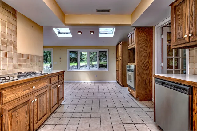 a large kitchen with stainless steel appliances a stove and cabinets