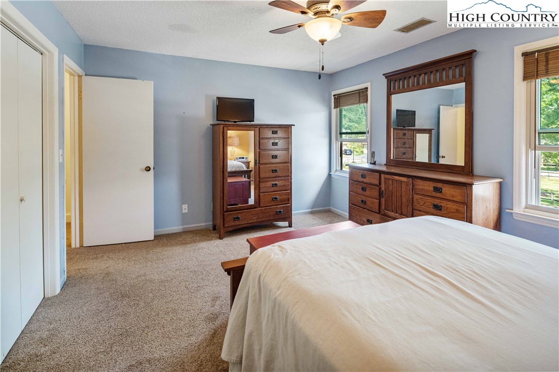 212 Carriage Lamp Court Boone, NC 28607 - Photo 15 of 29 a bedroom with a large bed and a chandelier