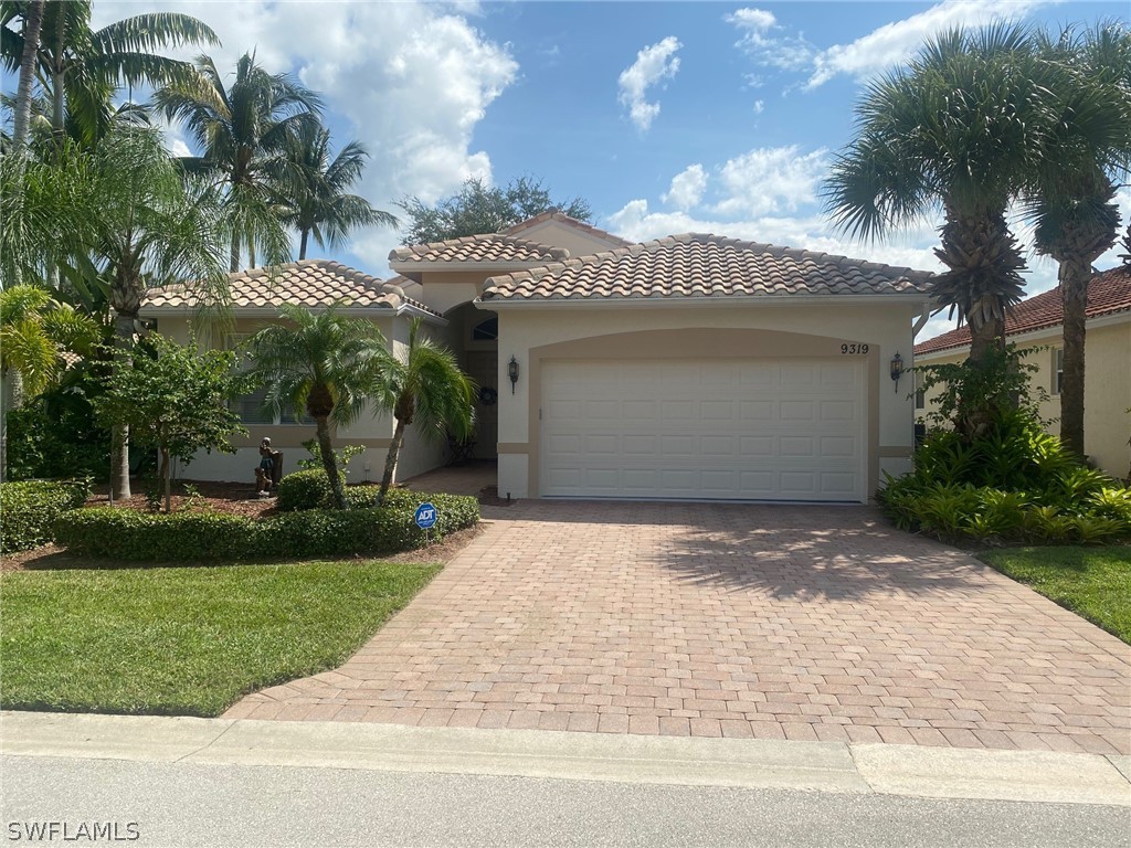 9319 Springview Loop Estero, FL 33928 - Photo 1 of 23 a view of a white house with a small yard and palm trees