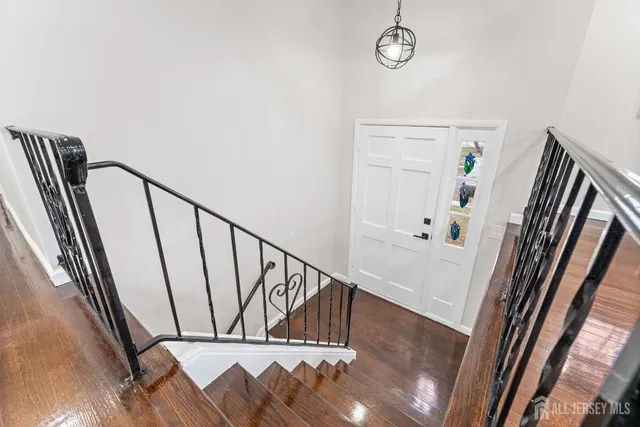 a view of staircase with railing and white walls