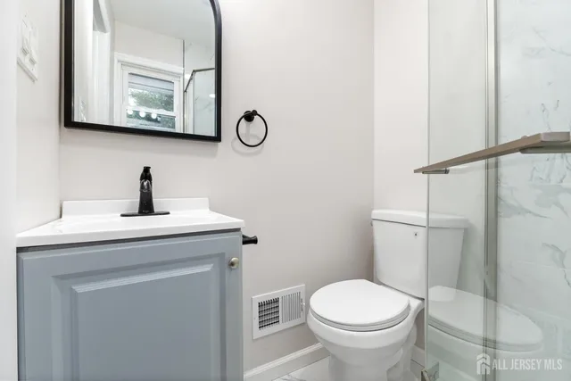 a bathroom with a toilet a sink and mirror