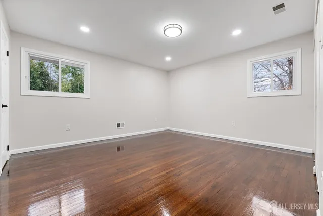 an empty room with wooden floor and window
