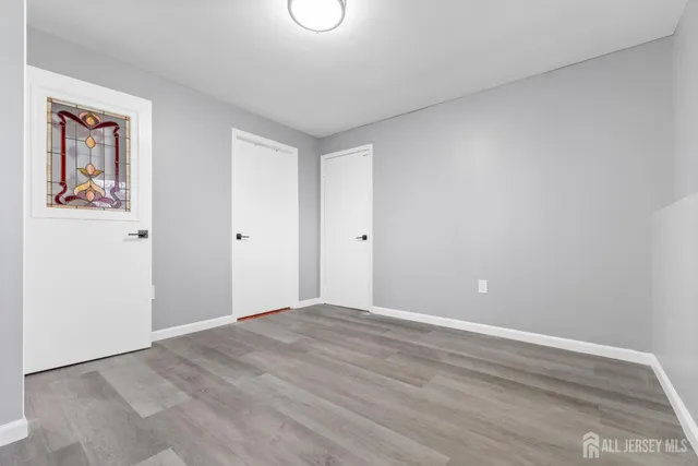 a view of an empty room with window and closet