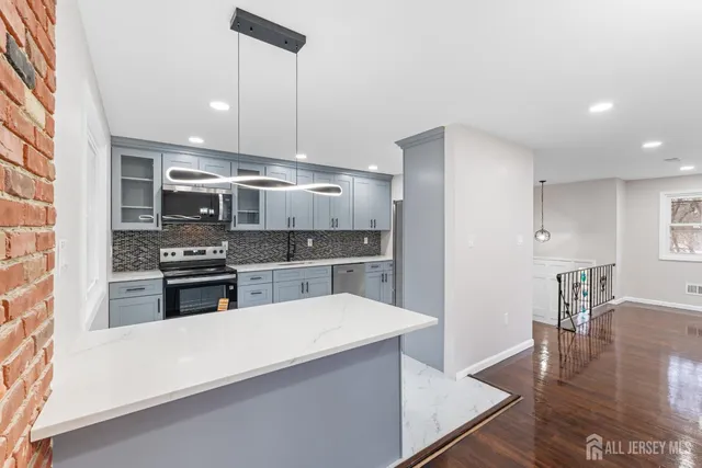 a kitchen with stainless steel appliances wooden floor sink and stove top oven