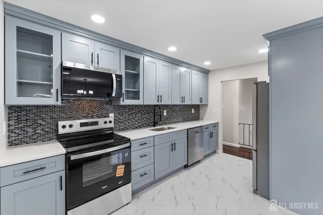 a kitchen with stainless steel appliances granite countertop a stove microwave and sink