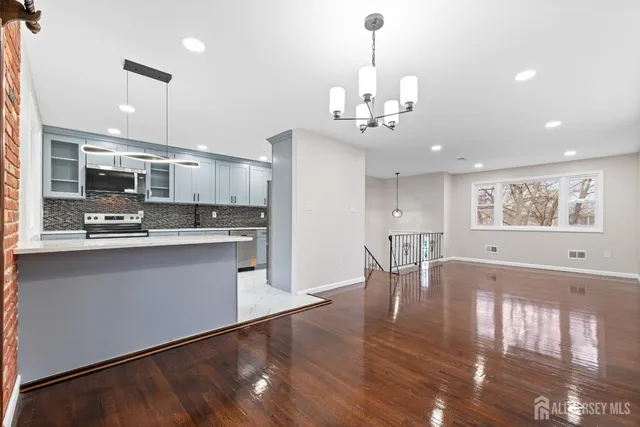 a large kitchen with kitchen island a sink stainless steel appliances and cabinets
