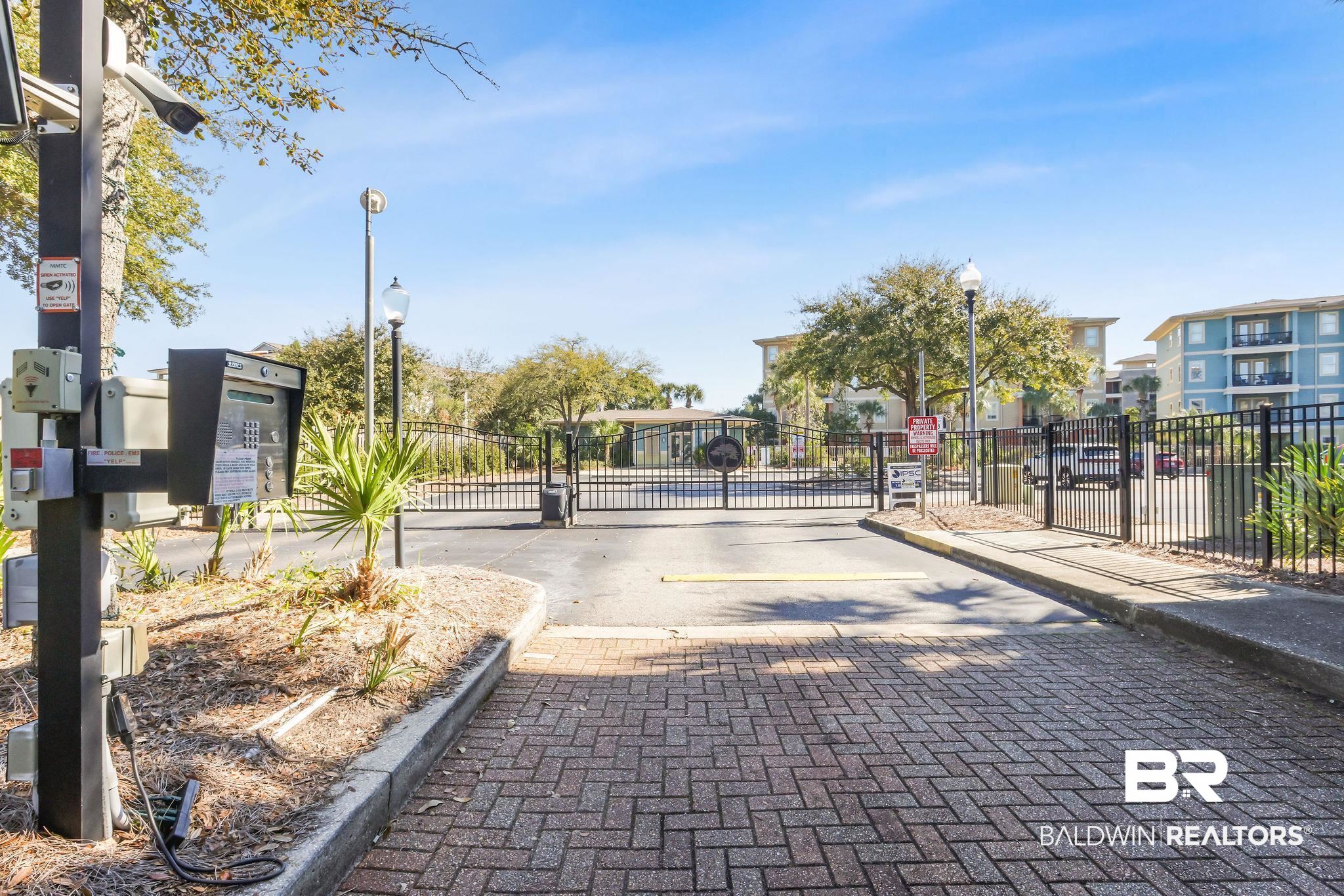 1430 Regency Road, Unit B302 Gulf Shores, AL 36542 - Photo 24 of 24 View of road featuring a gate, curbs, street lighting, and a gated entry
