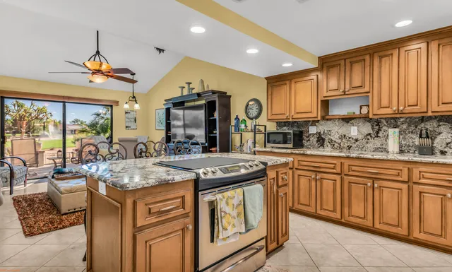 a kitchen that has a stove a table and chairs in it