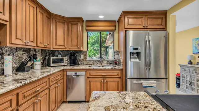 a kitchen with stainless steel appliances granite countertop a refrigerator sink and cabinets