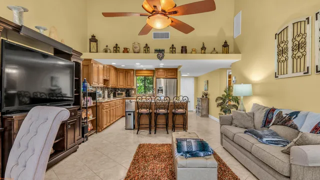 a living room with furniture a flat screen tv and kitchen view