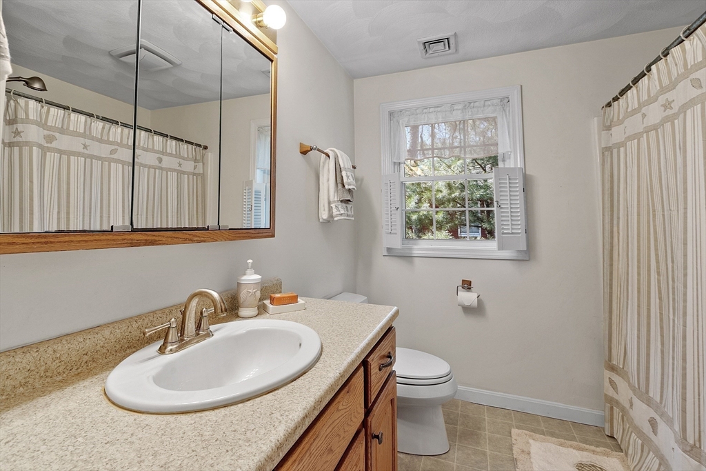 25 Hemlock Road Groton, MA 01450 - Photo 17 of 37 a bathroom with a toilet a sink a mirror and a shower
