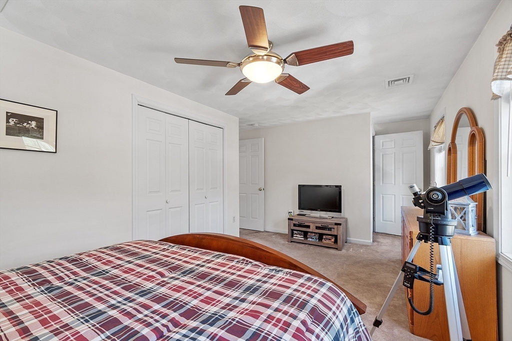 25 Hemlock Road Groton, MA 01450 - Photo 19 of 37 a bedroom with a bed and a flat screen tv