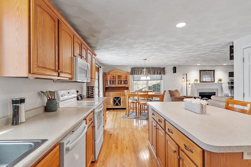25 Hemlock Road Groton, MA 01450 - Photo 4 of 37 a kitchen with stainless steel appliances granite countertop a sink dishwasher stove refrigerator dining table and chairs