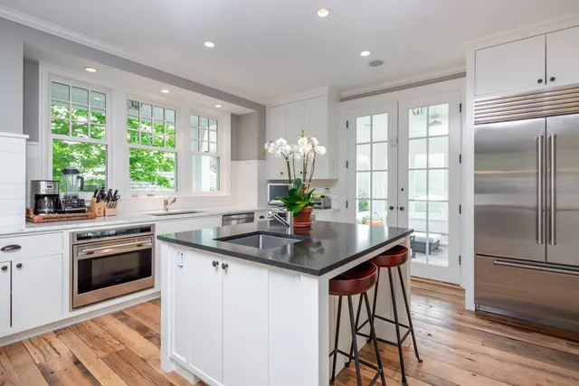 a kitchen with kitchen island a large counter top space appliances and a center island