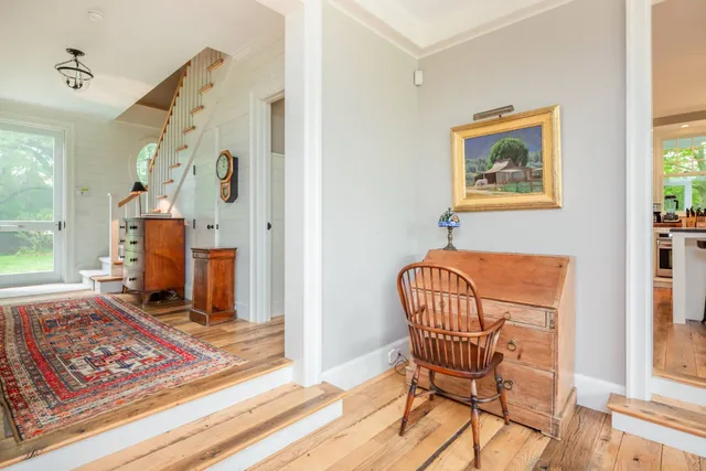 a view of a hallway with furniture and a window