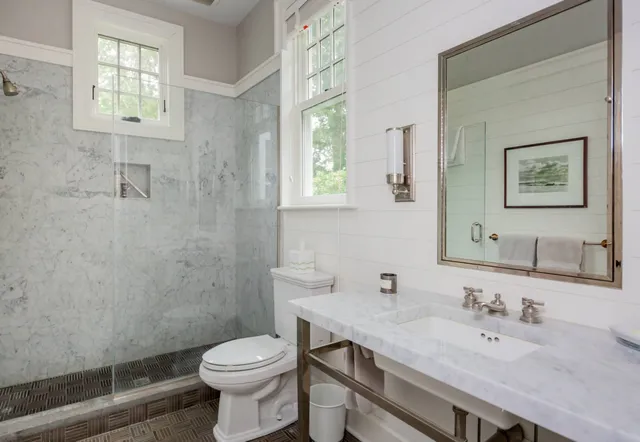 a bathroom with a granite countertop toilet sink and mirror
