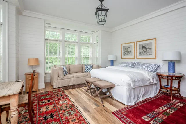 a spacious bedroom with a bed a table and chair