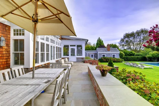 a view of a house with backyard and sitting area