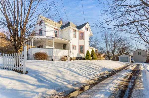 a view of a white house with a yard covered with snow in front of house