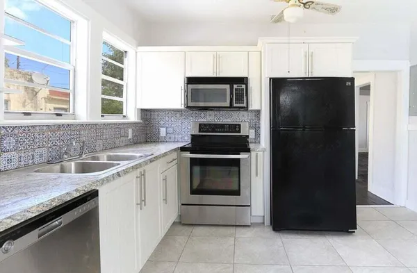 a kitchen with a refrigerator and a sink