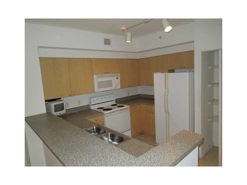 7940 North Nob Hill Road, Unit 204 Tamarac, FL 33321 - Photo 2 of 10 a living room with a table and chairs