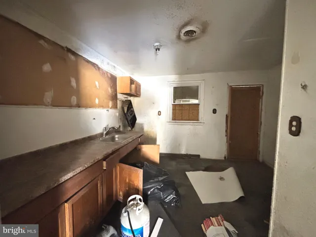a kitchen with a sink and a stove with wooden floor