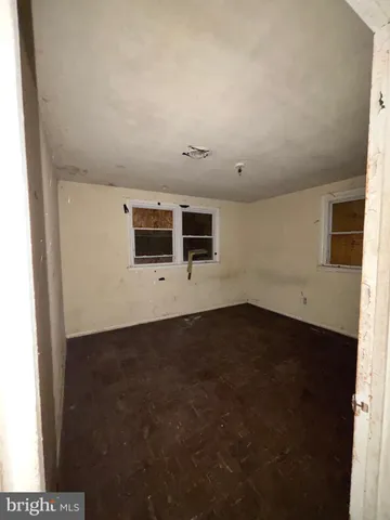 a view of a livingroom with an empty space & wooden floor