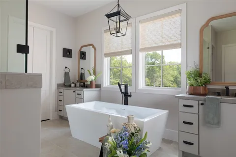 a living room with furniture a large window and a chandelier