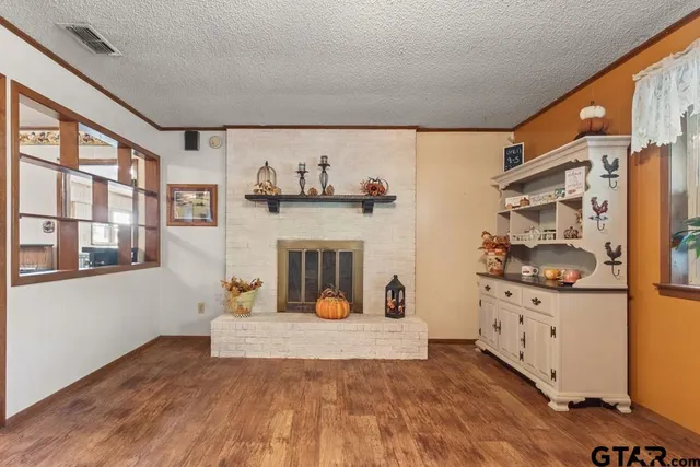 a view of a livingroom with wooden floor and a fireplace