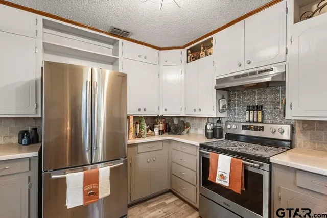 a kitchen with a refrigerator sink and cabinets